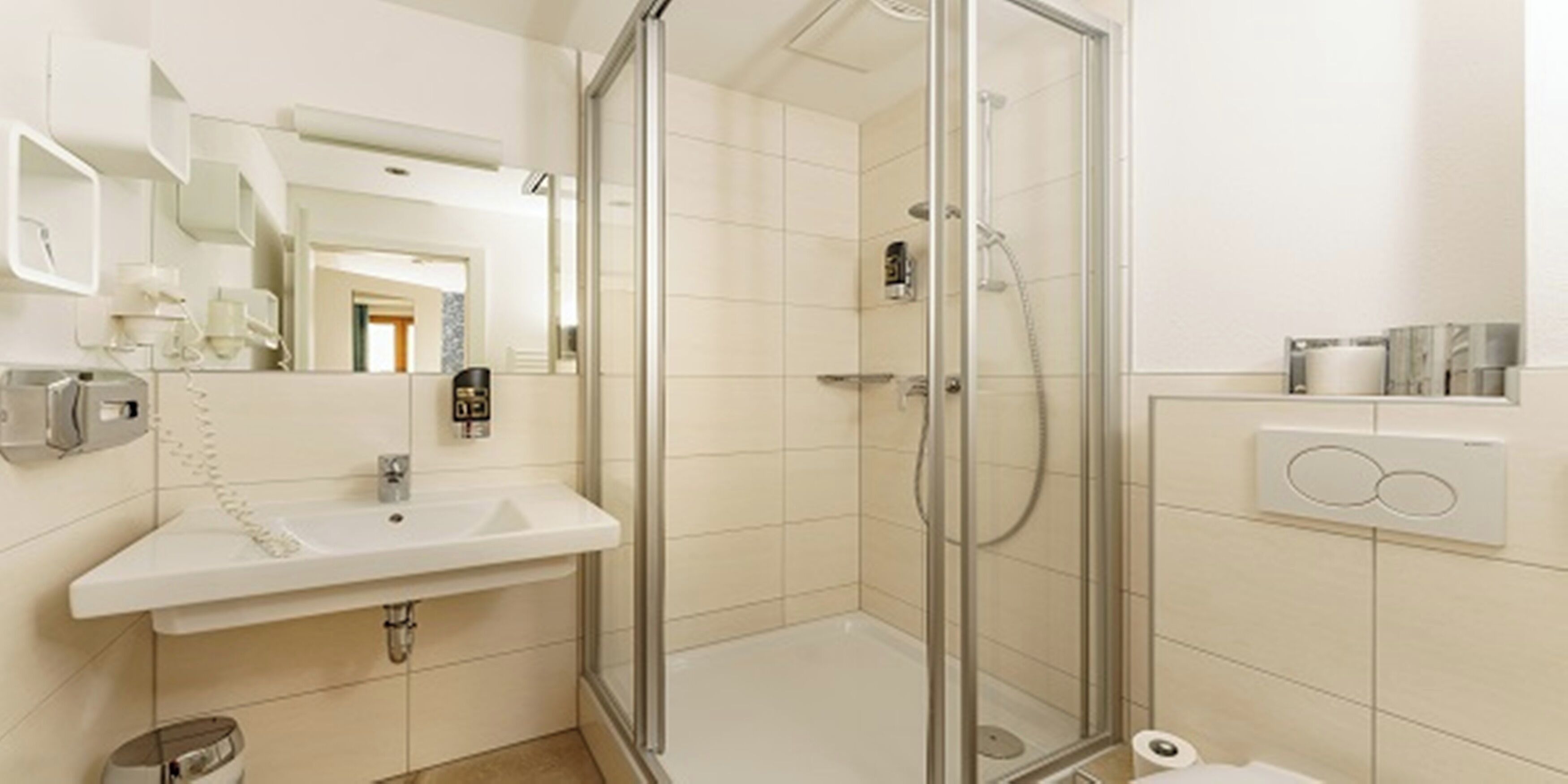 A modern bathroom with a glass-enclosed shower, a sink with a telephone, and a toilet.