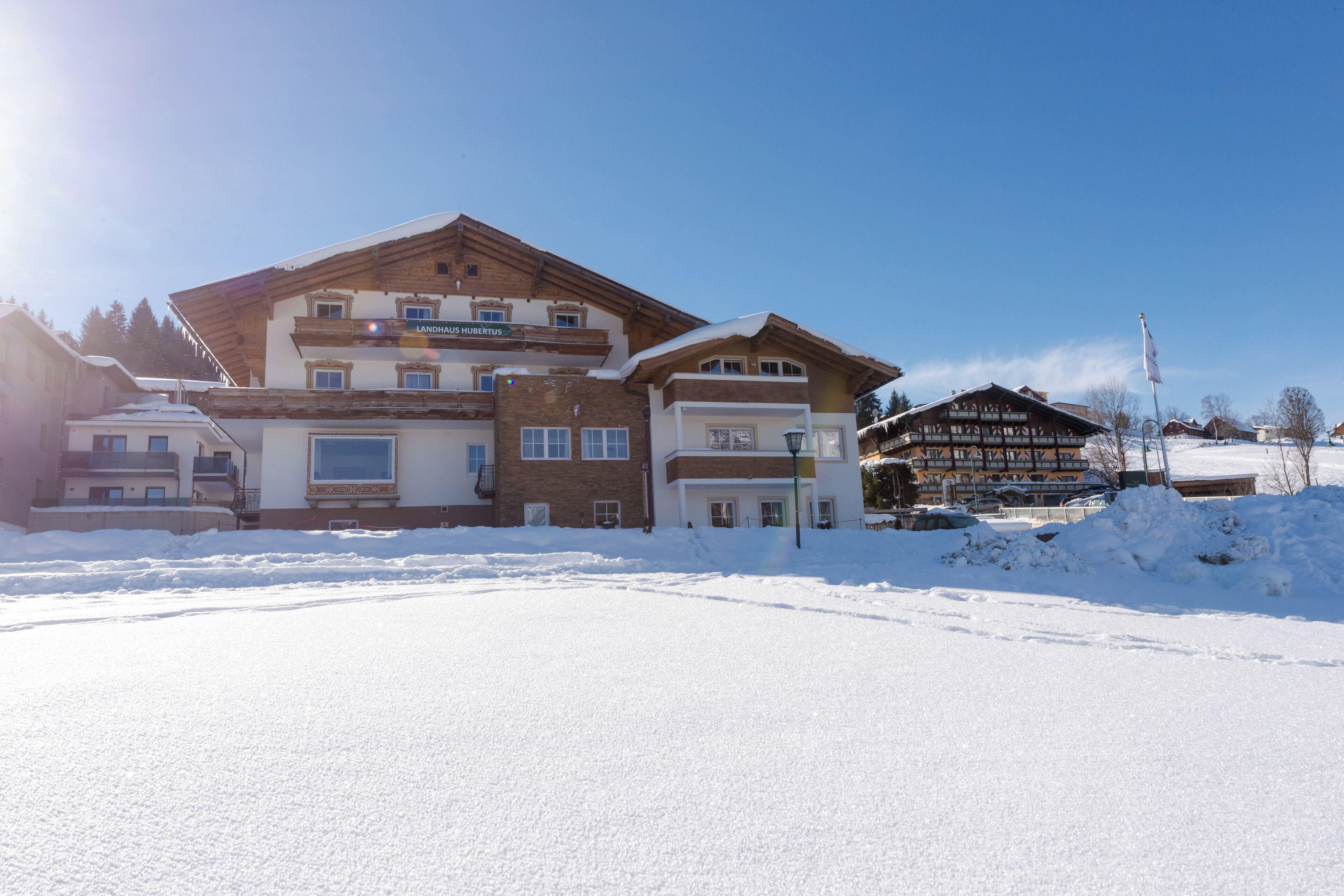 A multi-story hotel with a snow-covered ground, a clear sky, and a visible sign indicating the name of the hotel.