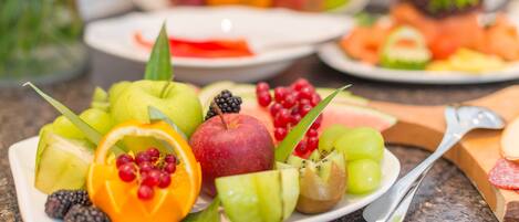 Un plato con una variedad de frutas, como manzanas, naranjas y bayas.