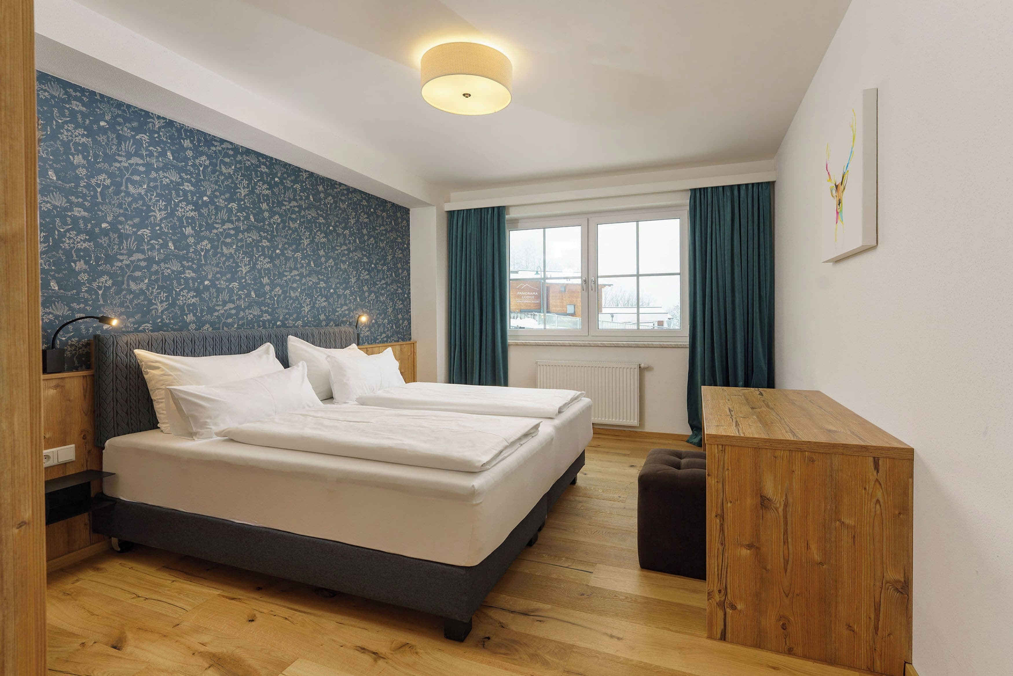 Ein Schlafzimmer mit einem Bett, einem Holztisch und einem Fenster mit Vorhängen.
