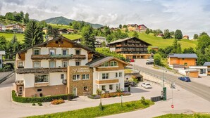 Un hôtel de style architectural alpin traditionnel, doté d'une enseigne bien visible et d'un jardin bien entretenu.