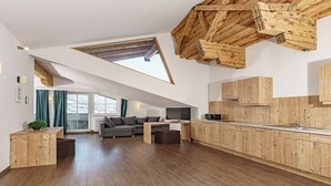 Une cuisine moderne avec des meubles en bois et un coin repas comprenant un canapé et une table basse.