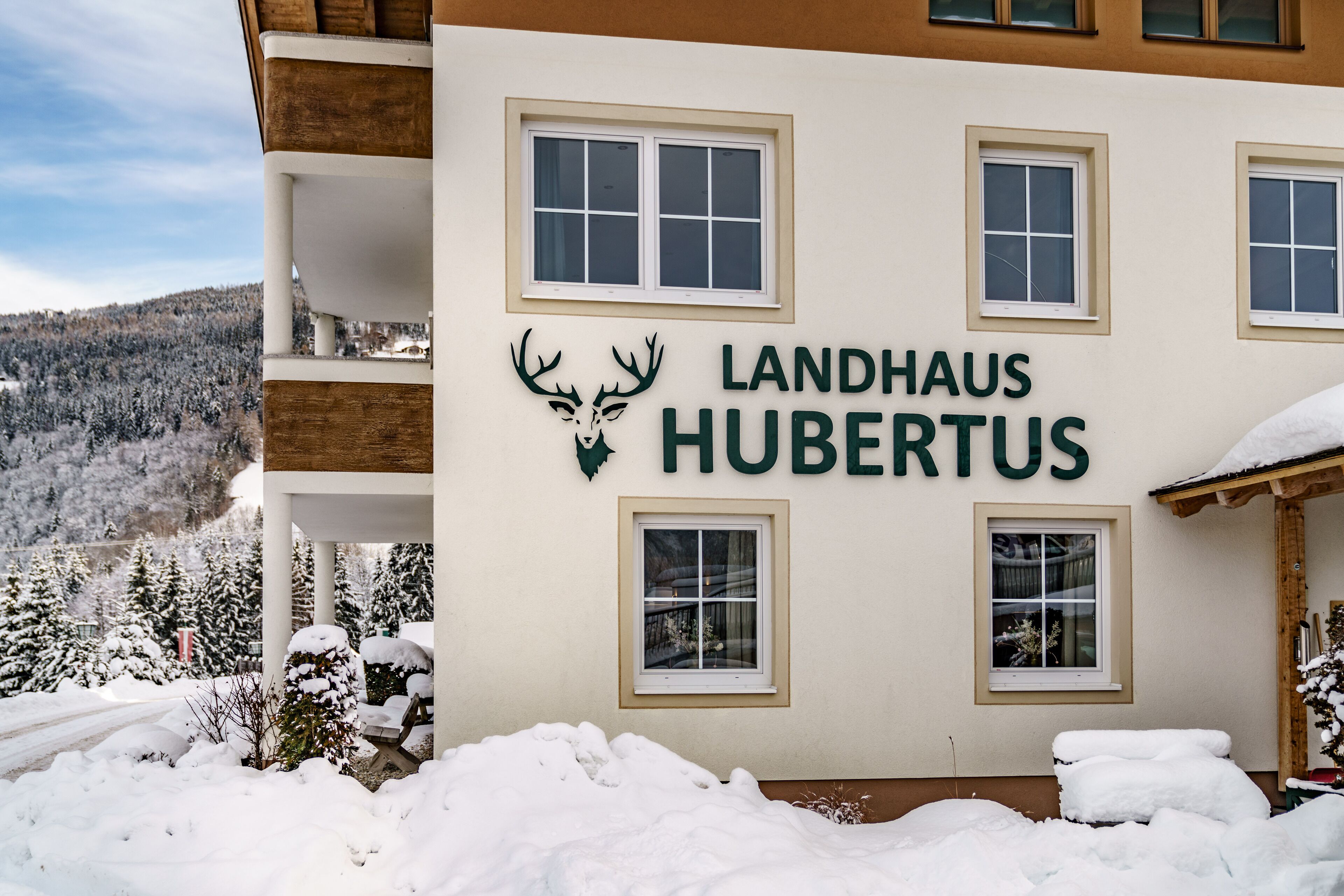 Un edificio con el letrero "Landhaus Hubertus" y un logotipo de ciervo.