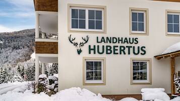Un edificio con el letrero "Landhaus Hubertus" y un logotipo de ciervo.