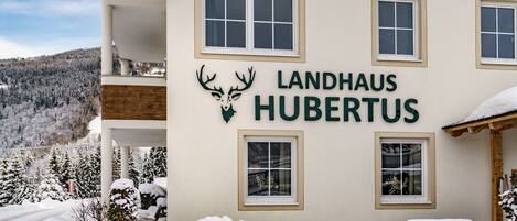 A building with the sign "Landhaus Hubertus" and a deer logo.