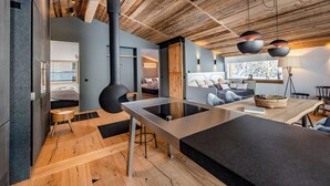 A modern kitchen with a central island, wooden ceiling, and built-in appliances.