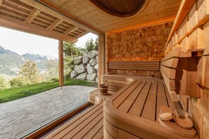 A wooden sauna with a stone wall and a view of the mountains. - Skylodge Alpine Homes (Haus)