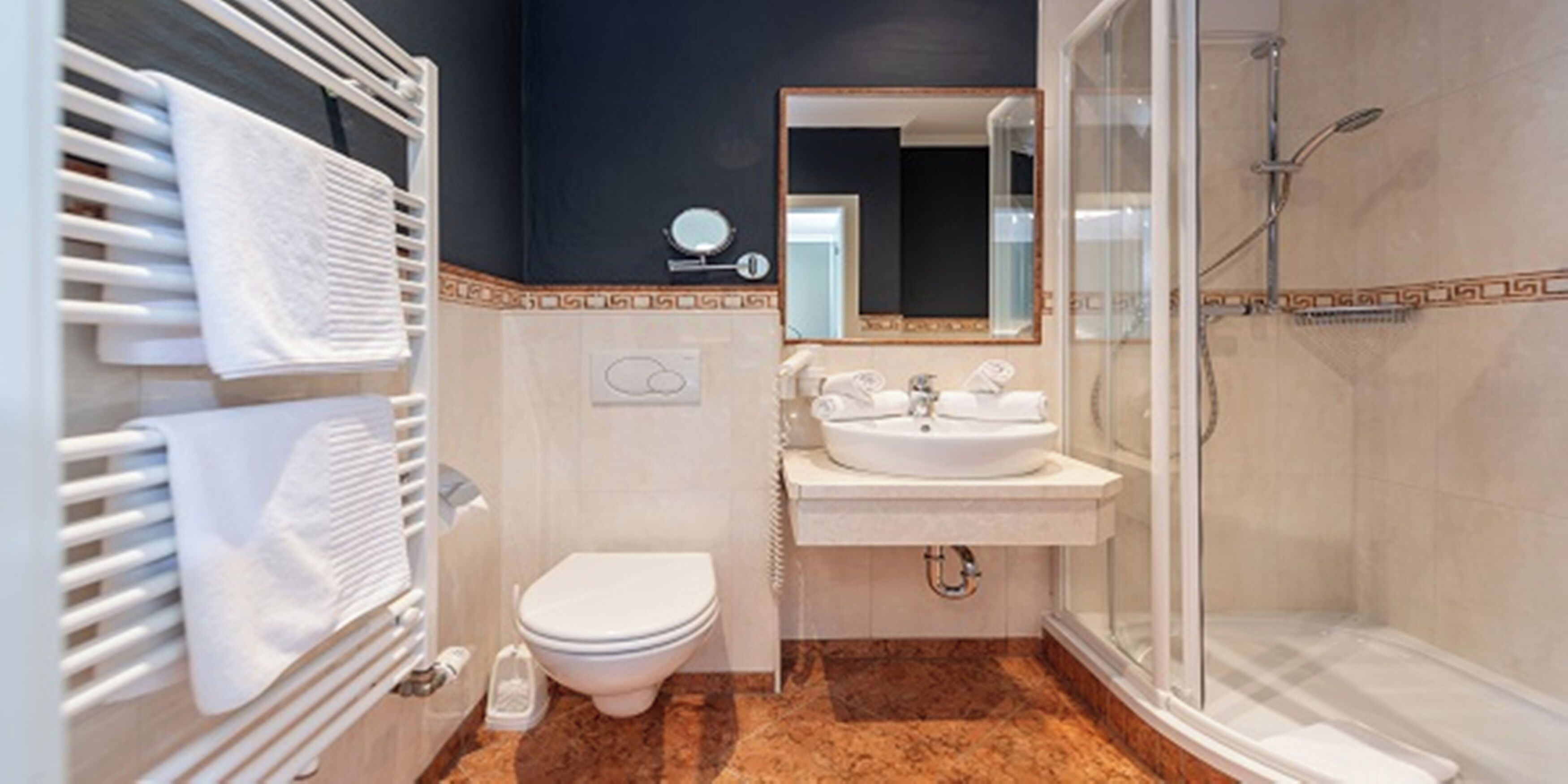 A modern bathroom with a white toilet, a sink, and a shower.