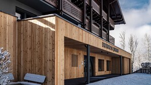 Een houten gebouw met een balkon en een bord waarop staat 