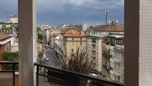 Vista urbana com edifícios, uma rua e céu nublado.