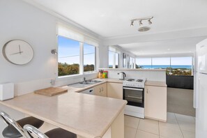 A modern kitchen with a large window, a built-in oven, and a refrigerator. - View Point (Anglesea)