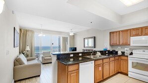 A modern kitchen with wooden cabinets, a white dishwasher, and a large island. - 🏖️20th FL FAB Gulf Views -3 Pools -1BR Ariel Dunes II 2006☀️ (Miramar Beach)