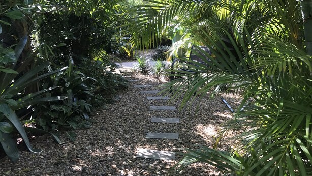 Un vialetto di giardino con pietre di mosaico immerso nel verde.