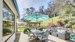 An outdoor patio with a table and chairs, a gazebo, and a stone wall. - Pet-Friendly Jackson Wine Country Home w/ Pool! (Jackson)