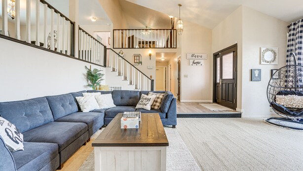 A spacious living room with a blue sectional sofa, a wooden coffee table, and a staircase leading to an upper level. - Pet-Friendly Jackson Wine Country Home w/ Pool! (Jackson)