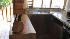 Una cocina de madera con un fregadero, un bloque de cuchillos y una estufa.