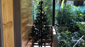 Un porche de madera con un árbol de Navidad, un farol colgante y un adorno de sol.