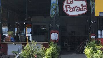 L’entrée d’un restaurant, avec une enseigne indiquant « La Parada », est agrémentée de plantes en pot et d’un vélo.