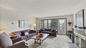 A living room with a sofa set, a coffee table, and a fireplace.