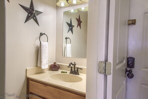 A bathroom with a sink, mirror, towel rack, and decorative stars.