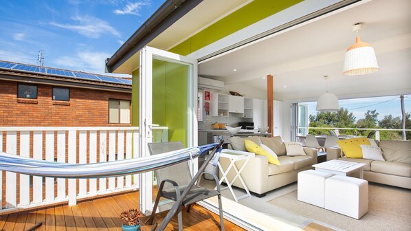 An open-plan living area with a balcony, a dining area, and a kitchen.