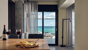 Un coin repas avec une table dressée pour deux personnes, une bouteille de vin et un plateau de fromages.