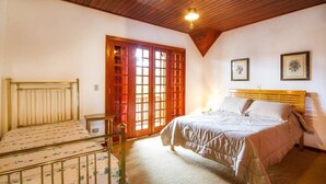 Un dormitorio con dos camas, techo de madera y un amplio ventanal con vistas.