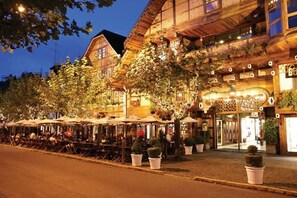 A traditional wooden building with outdoor seating and potted plants.