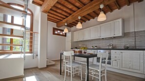 A modern kitchen with white cabinets, a wooden ceiling, and pendant lighting. - Lovely House in a Scenic Paiceful Location (Toscana)