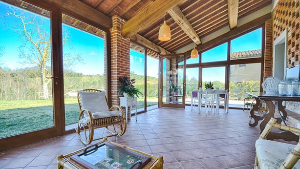 A spacious patio with wicker furniture, large windows, and a view of the outdoors. - Lovely House in a Scenic Paiceful Location (Toscana)