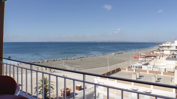 Ein Balkon mit Blick auf Strand und Meer.