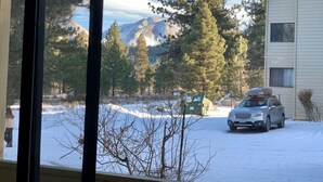 A snowy landscape with a car parked in front of a building. - Cozy Condo in a great location! (Mammoth Lakes)