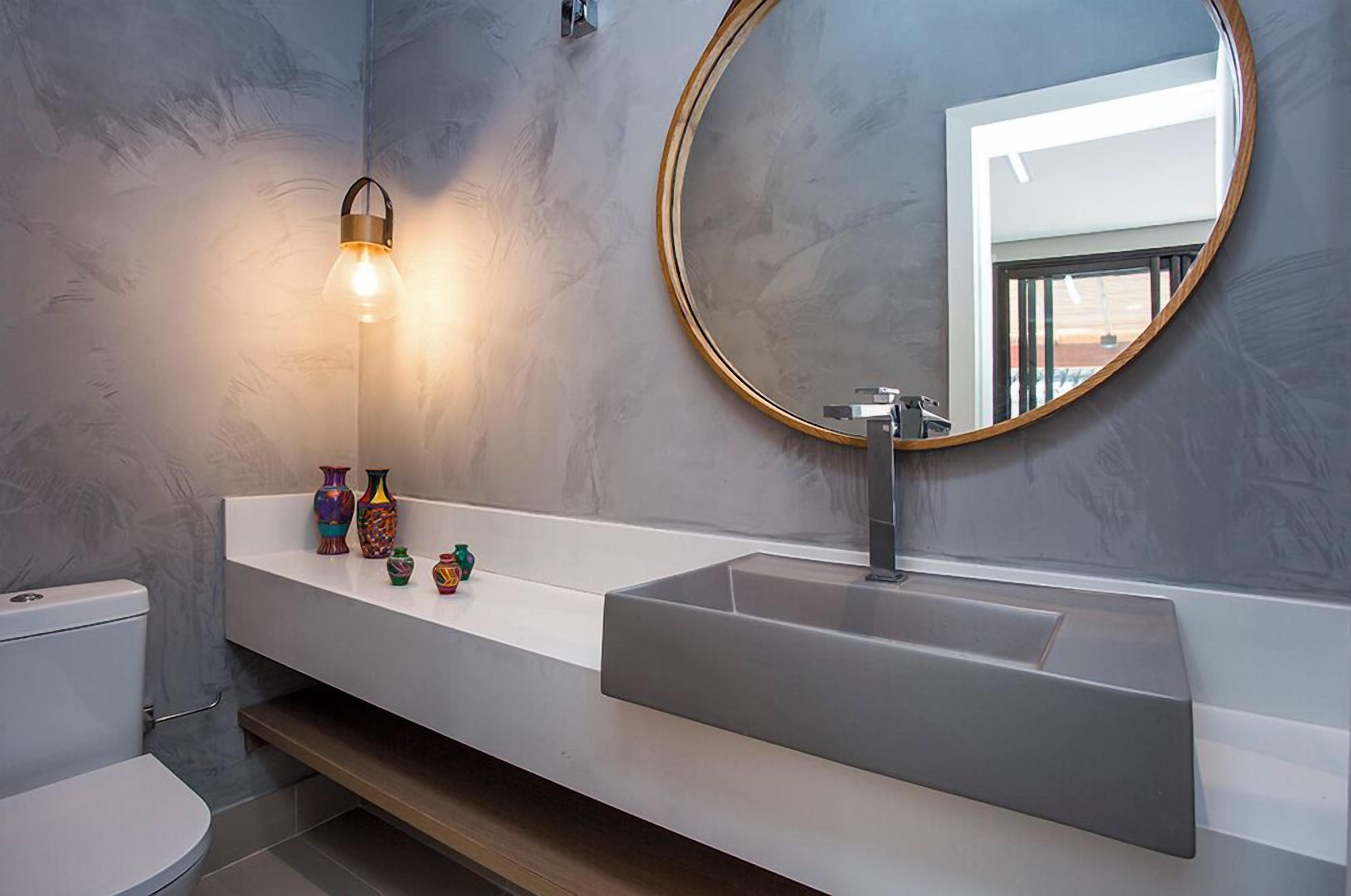Un baño de diseño moderno, con un espejo grande, un lavabo blanco y una lámpara.