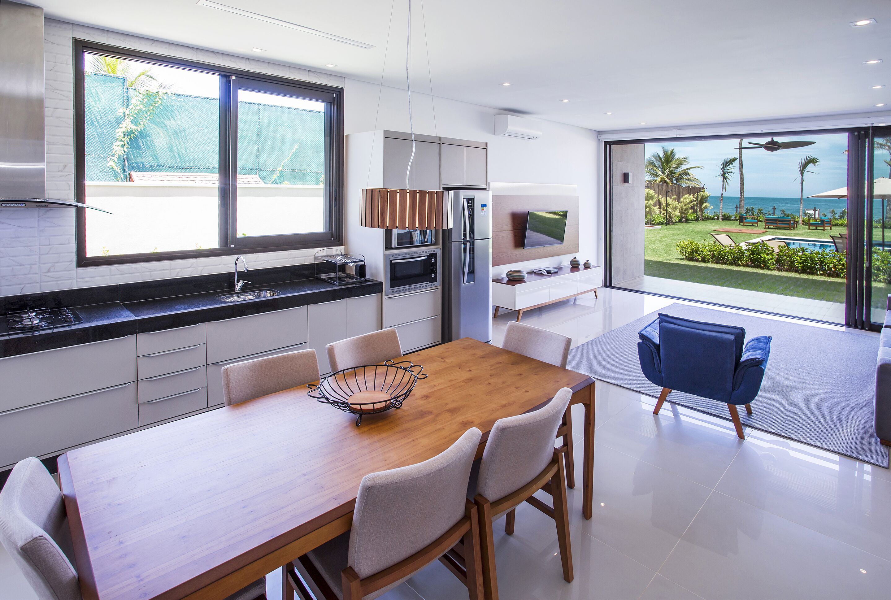 Una cocina moderna con comedor, ventanas amplias y vistas al exterior.