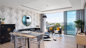 A modern living room with a dining area, large windows, and a view of the city. - Designer apartment close to the Waterfront (Cape Town)