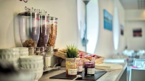 A buffet setup with various food items and condiments. - Zenitude Hotel-residences Bordeaux Aeroport Merignac (Merignac)