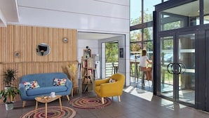 A modern interior with a blue sofa, yellow armchair, and a wooden panel wall. - Zenitude Hotel-residences Bordeaux Aeroport Merignac (Merignac)
