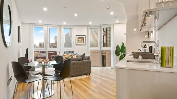 A modern kitchen with a sink, countertop, and a window overlooking the city. - One Bedroom Apartment at Alie Street in Aldgate London by MySquare (London)