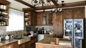 Eine Küche mit Holzausstattung, einer integrierten Kochinsel und einem Kühlschrank.