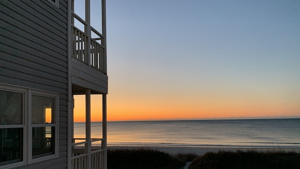 Ein Strandgrundstück mit Balkon mit Blick auf den Ozean.