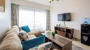 Een woonkamer met een bank, salontafel, televisie en waterdispenser.