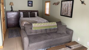 Ein Schlafzimmer mit Bett, Kommode und Schlafsofa.