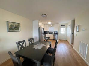 A compact kitchen with white cabinets, a refrigerator, and a dishwasher. - Tern Inn - Water Front - Townhouse, deep water dock. LINENS AND TOWELS, (Chincoteague)