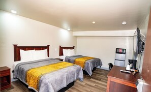 A hotel room with two beds, a desk, a TV, and a refrigerator. - Indian Mound Motel (Fairmont City)