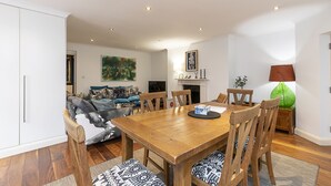 Un comedor con una mesa y sillas de madera, un sofá y una chimenea.
