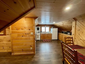 Un intérieur en bois comprenant un coin cuisine, une table à manger et une chaise.