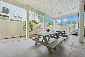 An outdoor patio with picnic tables and a barbecue grill. - Fun In The Sun, Luxury Beach House with Pool, Blocks from Beach (North Myrtle Beach)