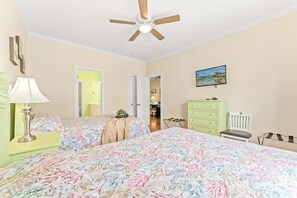 A bedroom with a bed, a ceiling fan, a dresser, a chair, and a painting on the wall. - Fun In The Sun, Luxury Beach House with Pool, Blocks from Beach (North Myrtle Beach)