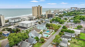 A coastal residential area with a mix of high-rise and low-rise buildings, a clear view of the ocean, and a swimming pool in a residential setting. - Fun In The Sun, Luxury Beach House with Pool, Blocks from Beach (North Myrtle Beach)