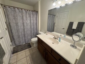 A bathroom with a toilet, sink, and shower curtain. - East Haven by Mesquite Vacation Rentals with Private Balcony with $510 in free daily activities (Mesquite)
